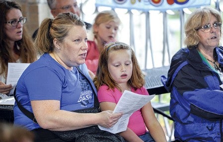 Erin Felten and her 7-year-old daughter Olivia sing along during the Minnesota Community Sings Tuesday night at Veterans Pavilion.  Eric Johnson/photodesk@austindailyherald.com