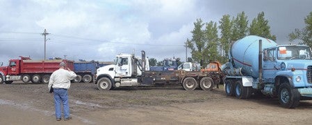 An auction goer examines Bustad Excavating Co. machinery Wednesday during Bustad’s heavy equipment auction. The longtime demolition and construction business is closing this week. Trey Mewes/trey.mewes@austindailyherald.com