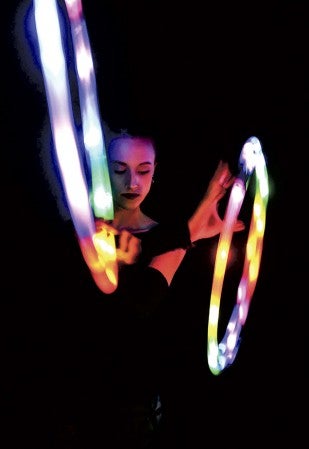 Rochelle Perleberg is lit by two of her glowing hula hoops. Eric Johnson/photodesk@austindailyherald.com