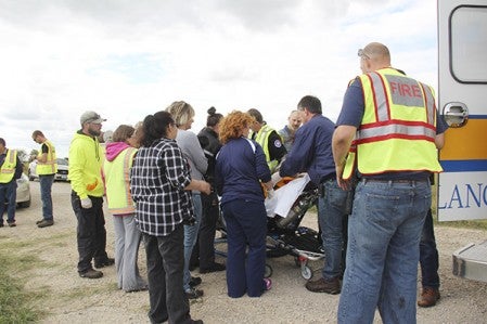 A 96-year-old woman is lifted into an ambulance with the help of first responders and volunteers on Friday. Sam Wilmes/Albert Lea Tribune