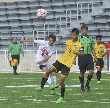 Austin's Tucker Nelson kicks the ball past Como Park's Tyler Johnson in Art Hass Stadium Saturday. Rocky Hulne/sports@austindailyherald.com