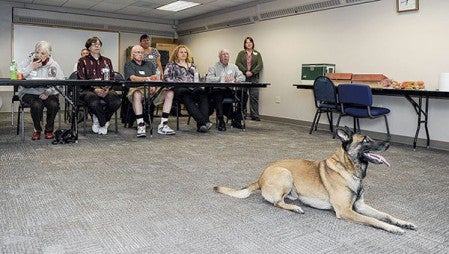 Members of the Austin Police Department’s Citizen’s Academy go through a presentation on the department’s K-9 program with K-9 officer Sonic sitting in the foreground.