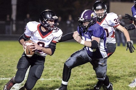 Grand Meadow’s Christophor Bain chases down Alden-Conger quarterback Kaleb Bendickson during the Section 1 9-Man tournament Wednesday night in Grand Meadow. Eric Johnson/photodesk@austindailyherald.com