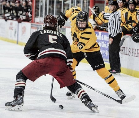 Austin’s Dalton Gally moves the puck against Minot’s James LaDouce during the second period Saturday night.