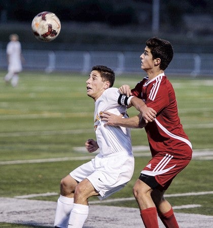 Austin’s Jace Greenman contends with Rochester Lourdes’ Esteban Bedoya for the ball during the second half of the Section 1A title game Thursday night in Rochester. Eric Johnson/photodesk@austindailyherald.com