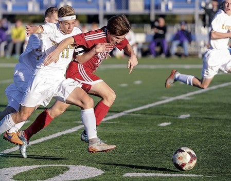 Austin’s Matias Parada battles with Rochester Lourdes’ Joe Novak during the first half of the Section 1A title game Thursday night in Rochester. Eric Johnson/photodesk@austindailyherald.com