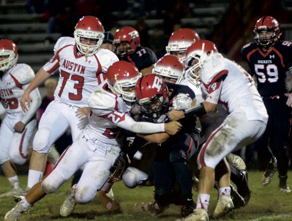 The Austin defense gang tackles a Rochester John Marshall ball carrier in a Section 1AAAAA quarterfinal game in Rochester Wednesday. Rocky Hulne/sports@austindailyherald.com