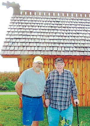 Ken Hartwig (left) and Gerald Meier stand beside the new Norwegian picnic shelter located along the Shooting Star Trail between Adams and Rose Creek. Photo provided.