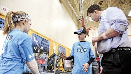 I.J. Holton Intermediate School students Carson Hjelmen and Izzy Hemann tell judge Coby Cost about their robot in the pit area Saturday during the Robotics VEX competition at Austin High School. Hjelmen and Hemann were members of the Holton Engineers A team. Herald file photo