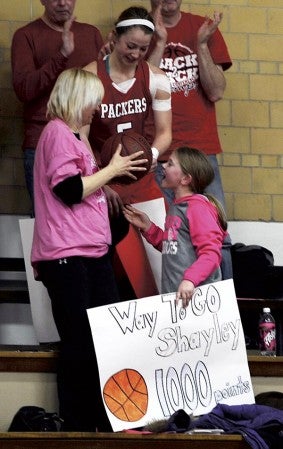 Shayley Vesel hands the basketball to her mother after getting her 1,000th point in Ove Berven Gym Thursday. Rocky Hulne/sports@austindailyherald.com