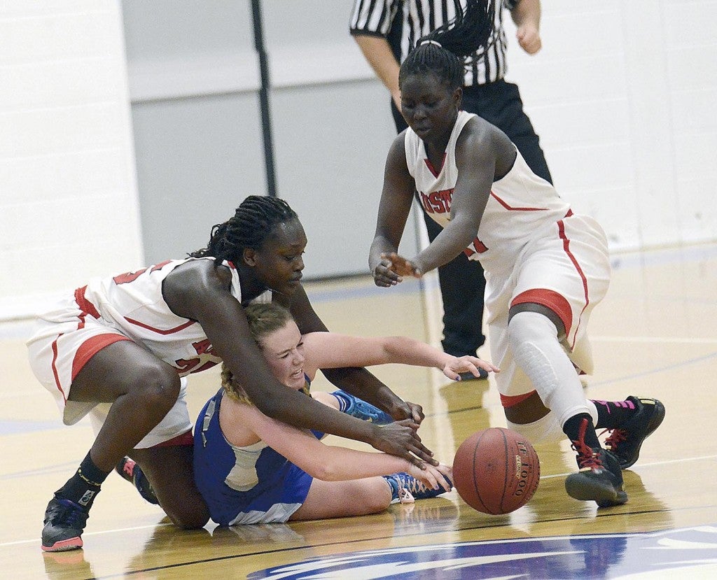Austin’s Ruth Koang, left, and Awenia Nywesh, hustle for a loose ball in Owatonna Tuesday. Jon Weisbrod/Owatonna People’s Press