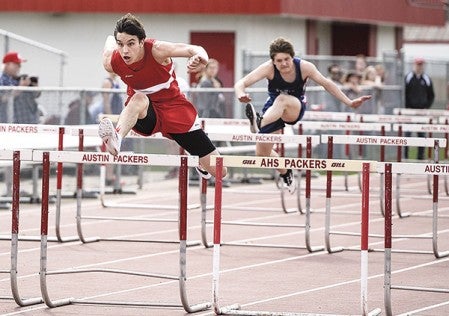 Austin’s Trent Brown heads to the win in the first heat of the 110-meter high hurdles against Albert Lea Friday at Larry Gilbertson Track and Field. Eric Johnson/photodesk@austindailyherald.com