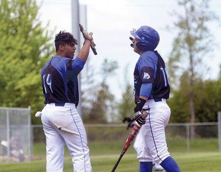 Luis Rodriguez and Carlos Torres celebrate a run for the Blue Devils against Minnesota West in Seltz Field Saturday. Rocky Hulne/sports@austindailyherald.com