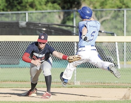 Austin Post 91 first baseman Jason Stoulil reaches for the throw as Owatonna’s Eric Benson lunges for the bag Thursday night at Marcusen Park. Eric Johnson/photodesk@austindailyherald.com