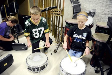 Kendyl Queensland, right, and Ty Laufenberg show off two of the drums the Grand Meadow fifth and sixth-grade band recently received. Eric Johnson/photodesk@austindailyherald.com