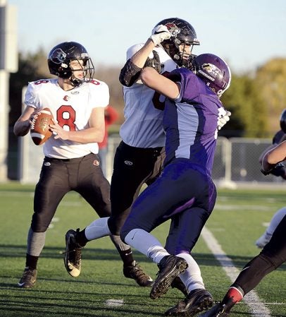 Grand Meadow’s Connor King pushes his way through a block on the way to Spring Grove quarterback Alex Folz during the first quarter of the Section 1 Nine Man championship last Friday night at Rochester Community and Technical College. Herald File Photo