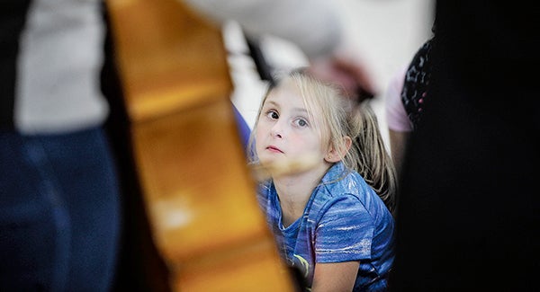 Southgate Elementary third-grader Alexa Kraft watches cellist Olivia Diercks and violinist Karla Dietmeyer — OK Factor — play for them Friday afternoon. Eric Johnson/photodesk@austindailyherald.com