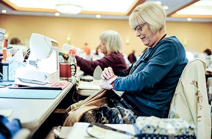 Kathy Sturtevant of Woodward, Iowa, pins the front and back together of her quilt before sewing them together Saturday afternoon during the Calico Hutch Quilters Retreat at the Holiday Inn and Convention Center. This was the first of two retreats that started this weekend and runs through Wednesday. 