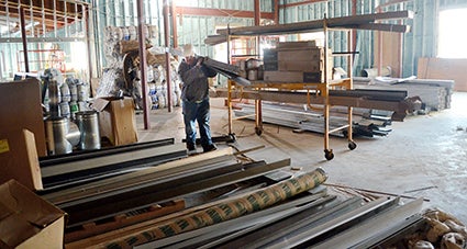 A worker carries materials into the space that will house exhibits. Deb Nicklay/deb.nicklay@austindailyherald.com