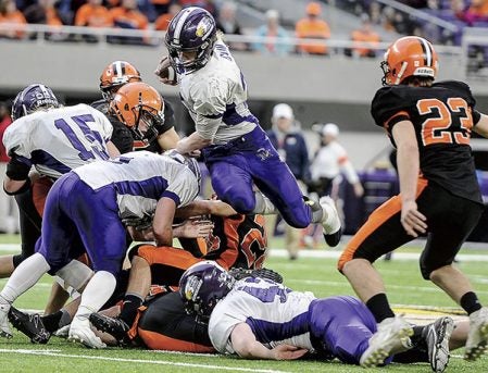 Grand Meadow’s Christophor Bain leaps over the line of scrimmage against Cleveland-Immanuel Lutheran in the third quarter of the Minnesota State Nine Man Prep Bowl Friday morning at U.S. Bank Stadium. Eric Johnson/photodesk@austindailyherald.com