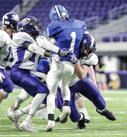 Grand Meadow’s Connor King, right, and Wes Ojulu put pressure on Waubun quarterback Peyton Syverson during the third quarter in the Minnesota State Nine Man semfinals Friday at U.S. Bank Stadium in Minneapolis. Eric Johnson/photodesk@austindailyherald.com