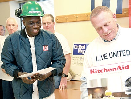 Quality Pork Processors worker Olumide Ademola smiles as he goes to pick up a mixer he won in a raffle after giving to the United Way’s annual campaign at the plant Wednesday. QPP and the United Way anounced that QPP raised $141,000 for the United Way’s annual drive. 