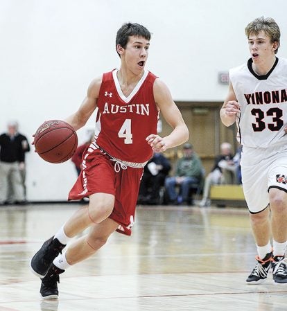 Austin’s Tate Hebrink drives past Winona’s Jake Reeck during the second half Thursday night in Packer Gym. Eric Johnson/photodesk@austindailyherald.com