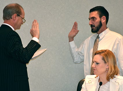 New Third Ward councilman Paul Fischer is sworn into office Tuesday by Director of Administrative Services Tom Dankert. New First Ward councilwoman Laura Helle is in the foreground. Deb Nicklay/deb.nicklay@austindailyherald.com