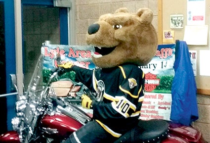 Bruiser sits on the Harley-Davidson motorcycle being raffled. Photo provided