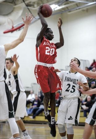 Austin’s Jany Gash passes in traffic during the second half Tuesday night in Packer Gym against Faribault. Eric Johnson/photodesk@dailyherald.com