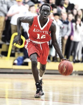 Austin’s Ngor Deng pushes the ball off the point during the first half Tuesday night against Faribault. Eric Johnson/photodesk@austindailyherald.com