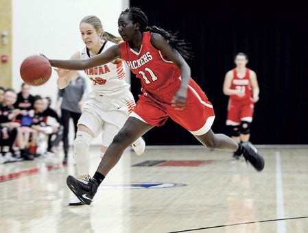 Austin’s Awenia Nywesh reaches out for a loose ball against Winona in the first half Friday night in Ove Berven Gym. Eric Johnson/photodesk@austindailyherald.com