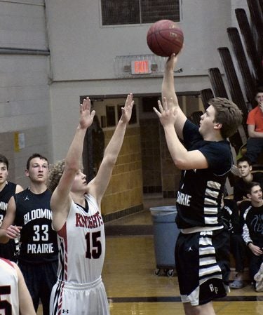 Blooming Prairie’s Seth Bendenbaugh pulls up for a shoot over Kenyon-Wanamingo’s Calvin Steberg in BP Friday. Rocky Hulne/sports@austindailyherald.com