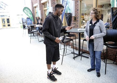 Robert Dansby, a student at Riverland Community College, is given an Amazon gift card by Primose employee Annette Ross Friday for Random Acts of Kindness Day Friday night. Eric Johnson/photodesk@austindailyherald.com