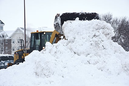 Mower County crews dig out in the parking lot across from the Jail and Justice Center on Friday morning after about 9 inches of snow overnight. 