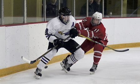 Austin's Isaac Arnold shoves Red Wing's Ryan Swanson while going for the loose puck during the third period of Saturday's Big Nine Conference game at Prairie Island Arena in Red Wing. Photo by Joe Brown/Red Wing Republican Eagle