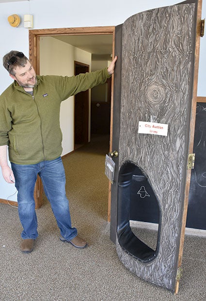 Nature Center Director Luke Reese checks out the “tree door” that will be up for sale during the silent auction on Saturday. The door was part of the early childhood area of the old interpretive center. Photos by Deb Nicklay/deb.nicklay@austindailyherald.com