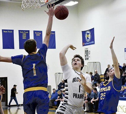 Blooming Prairie’s Seth Bedenbaugh hoists a shot over Hayfield’s Mason Tapp in Hayfield this season. 