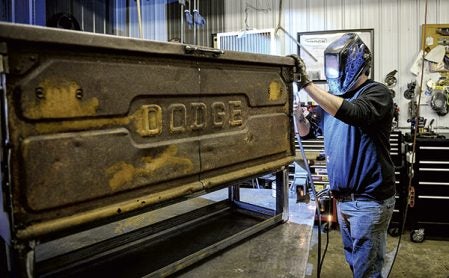 Brian Quail welds on furniture art featuring the tailgate of a Dodge truck. It’s part of what sets Quail’s art and furniture apart from others Eric Johnson