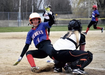 Southland’s Lexi Smith slides into home plate as Saint Charles catcher Daysia Stangler holds her ground in Rose Creek Monday. Rocky Hulne/sports@austindailyherald.com