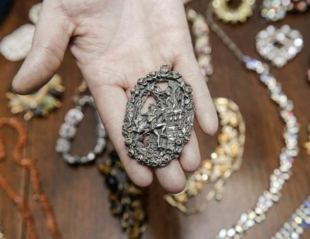 Jen Bute shows off pewter pendent depicting Romeo and Juliet. Eric Johnson/photodesk@austindailyherald.com