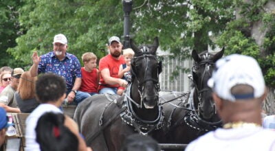 Freedom Fest Parade Grand Marshall Mike Ankeny rides on a horse trailer. Rocky Hulne/sports@austindailyherald.com