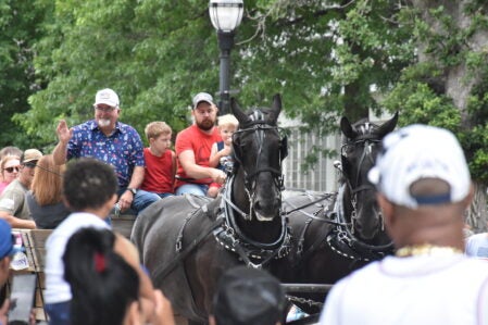 Freedom Fest Parade Grand Marshall Mike Ankeny rides on a horse trailer. Rocky Hulne/sports@austindailyherald.com